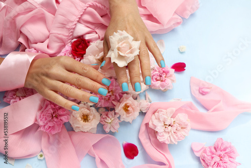 Blue manicure on short nails with pink roses.