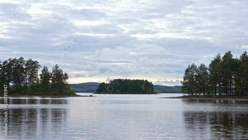 Siljan lake panorama timelapse. Clouds move fast over the beach of Tällberg village, municipality of Leksand, County of Dalarna. Large flat lake with picturesque islands and Scandinavian vegetation. photo
