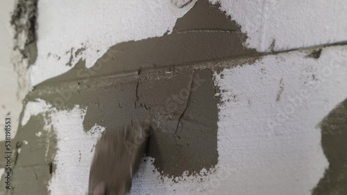 plaster is applied to the foam, insulation of the facade of the house