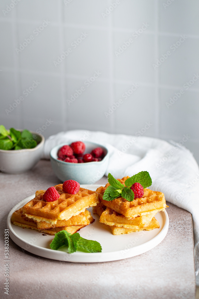 Belgian waffles in white plate raspberry mint breakfast Belgian waffles in white plate raspberry mint breakfast
