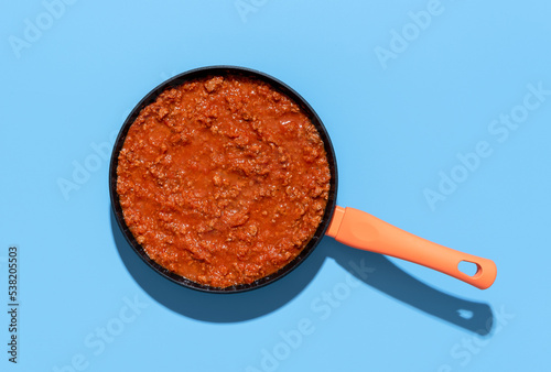 Sauce bolognese top view. Pan with ragu sauce on a blue background photo