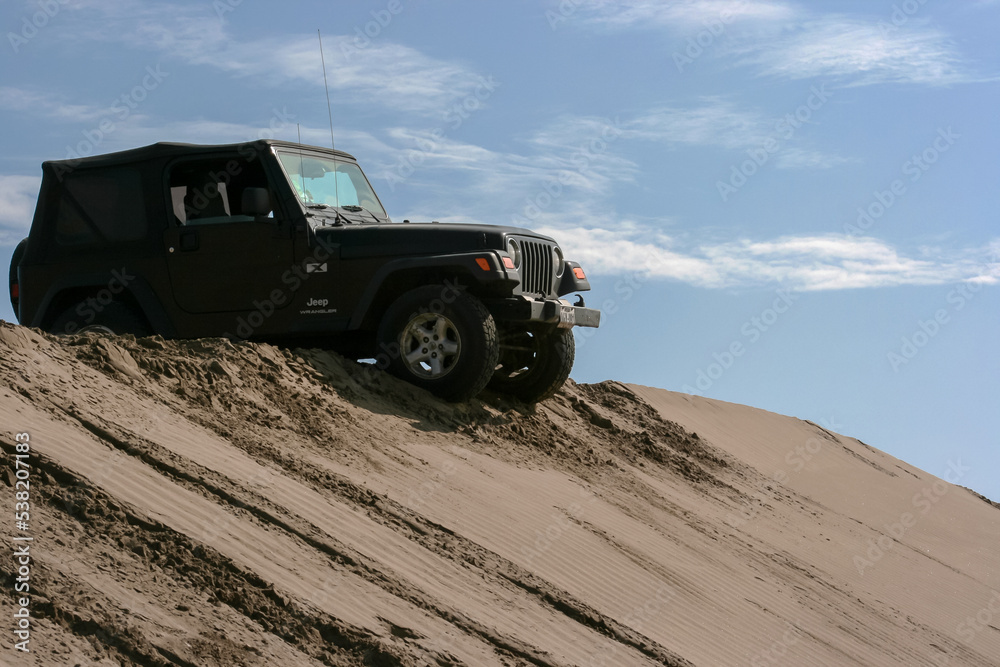 Lima, Peru; June 2014: Jeep Wrangler doing some off road driving in the Peruvian dessert with some dunes.