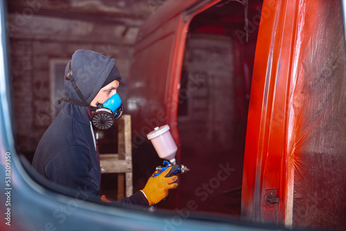 Spray painting a van car red. Restoration and body repair of cars photo