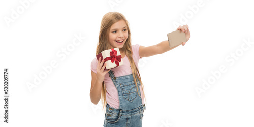 Happy girl taking selfie with present box studio. Teenager smiling to smartphone making birthday selfie © be free