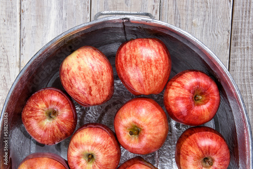 High angle closeup of a metal tub filled with water and apples for the Halloween custom of Apple Bobbing. photo