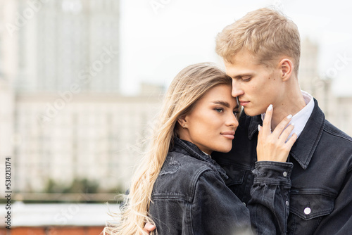 Beautiful happy young loving couple on a surprise date on a Saint Valentine's Day. Romantic modern wedding on the rooftop, summertime. Young man and beautiful girl. Newlyweds on honeymoon