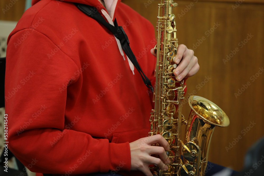 Obraz premium The person in red playing the saxophone