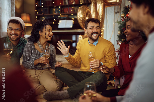 Cheerful man has fun while drinking wine with his friends on New Year's party at home.