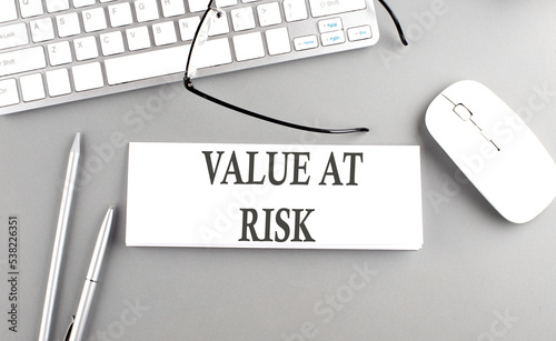 VALUE AT RISK text on notepad on chart with keyboard and calculator on grey background