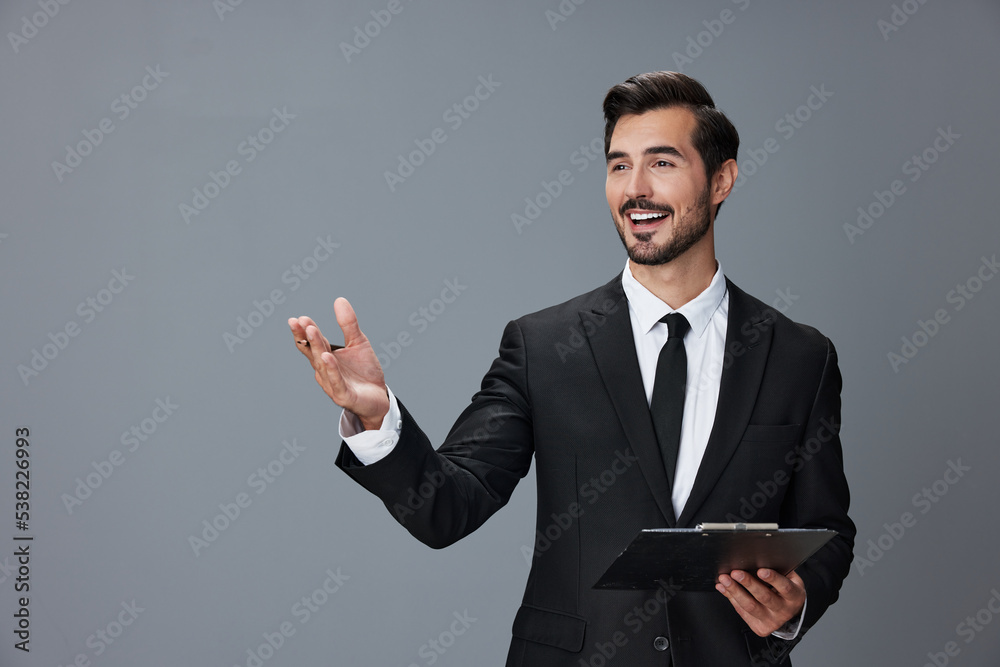 Portrait of a business man in a stylish suit smile with teeth hands up handsome face on gray isolated background with tablet in hand. Business concept young businessman startup copy space.