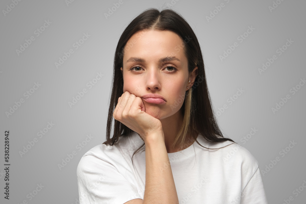 Portrait of bored young woman with head on chin isolated on gray Portrait of bored young woman with head on chin isolated on gray