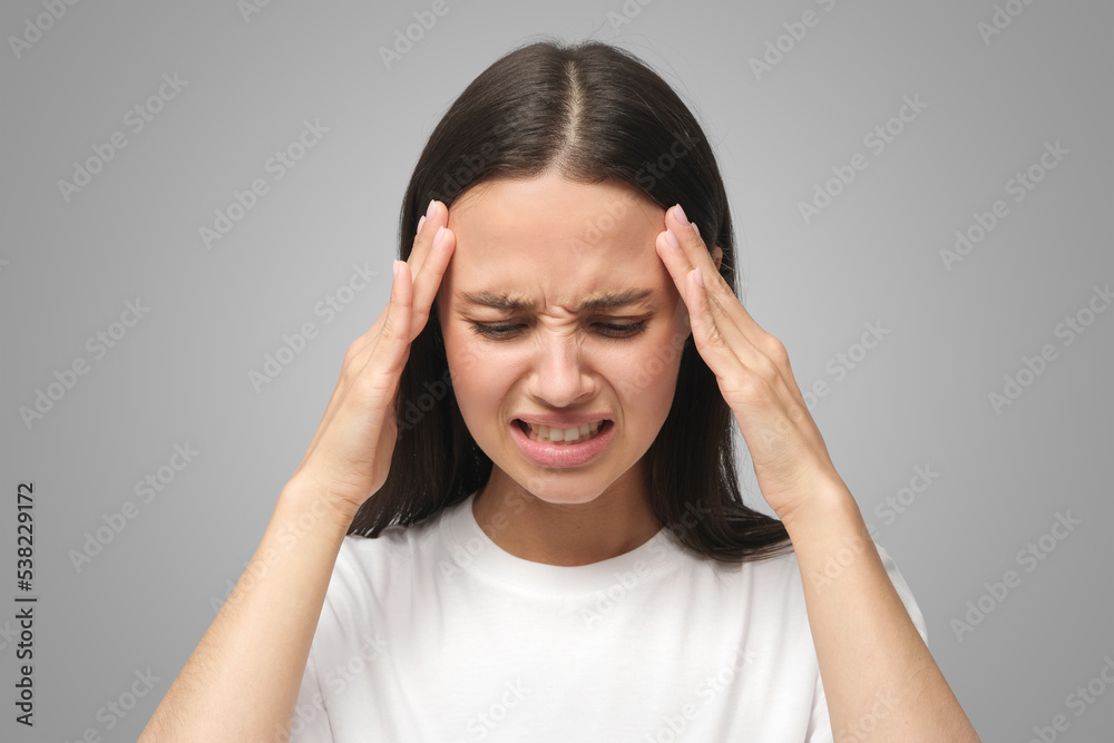 Upset unhappy woman squeezing head with hands, suffering from headache, tension and migraine Upset unhappy woman squeezing head with hands, suffering from headache, tension and migraine