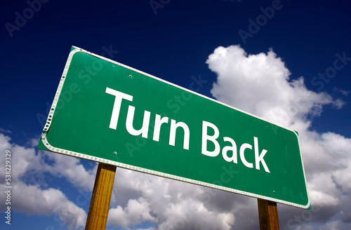 Turn Back Green Road Sign Under Cloudy Blue Skies photo