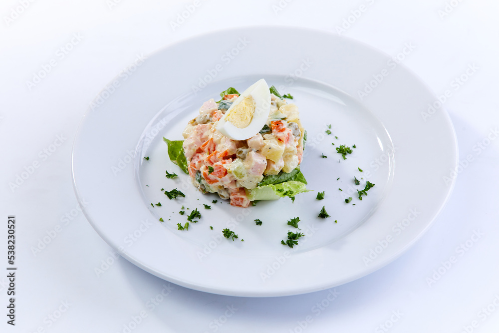 traditional russian salad on white plate traditional russian salad on white plate