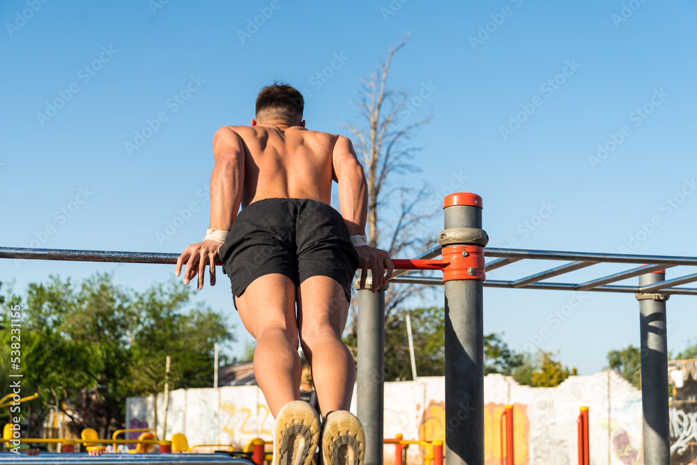 Fototapeta premium sportswoman doing outdoor gymnastics, athlete, calisthenics