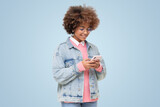 African american girl with afro hair, glasses and earphones holding phone using social media app