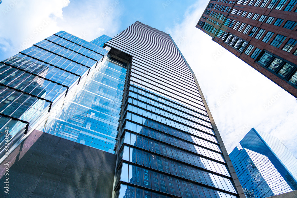 Φωτογραφία Towers of skyscrapers made of glass and concrete leaving their peaks in the blue