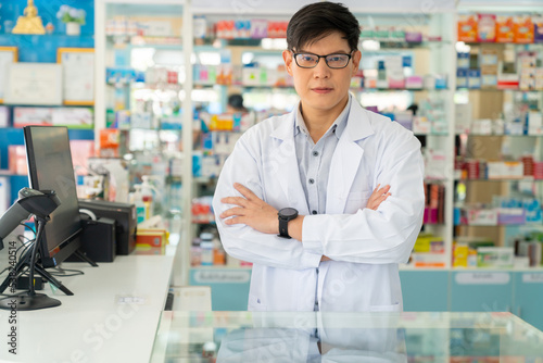 Portrait of Handsome Asian man professional pharmacist ready for medication advice about health  medicine  drugs and supplements in modern drugstore. Medical pharmacy and healthcare providers concept.