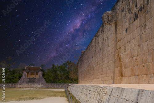 Stone wall with a ring of Grand Ball Court, Gran Juego de Pelota of Chichen Itza archaeological site in Yucatan, Mexico with Milky Way Galaxy stars night sky photo