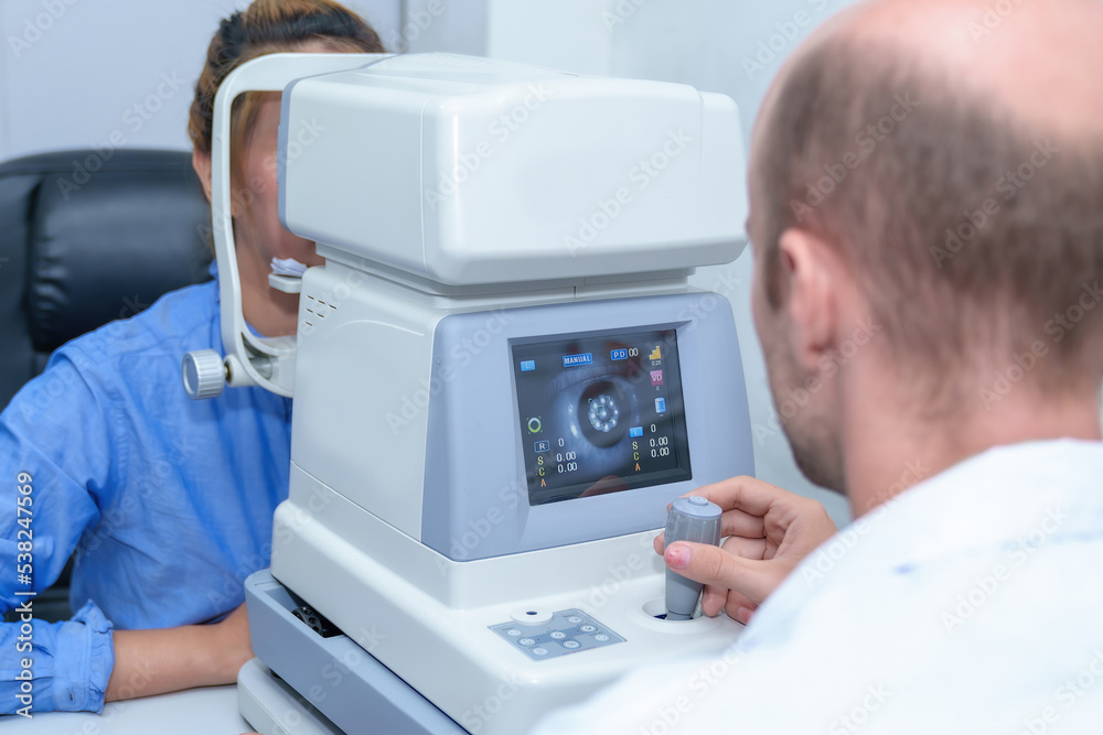 Handsome male ophthalmologist is examining the vision of an attractive young woman in a modern clinic, doctors and patients in ophthalmology clinics. Handsome male ophthalmologist is examining the vision of an attractive young woman in a modern clinic, doctors and patients in ophthalmology clinics.