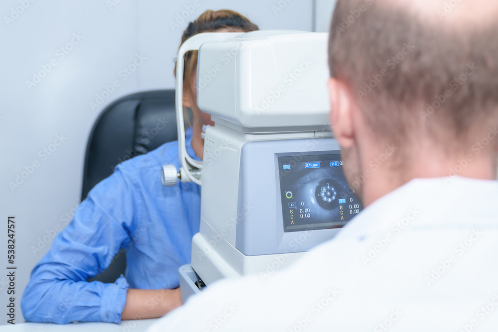 Handsome male ophthalmologist is examining the vision of an attractive young woman in a modern clinic, doctors and patients in ophthalmology clinics. Handsome male ophthalmologist is examining the vision of an attractive young woman in a modern clinic, doctors and patients in ophthalmology clinics.