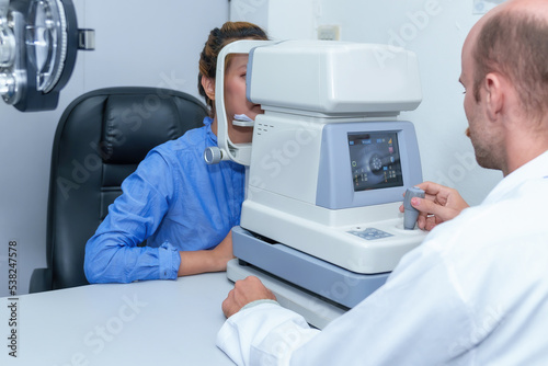 Handsome male ophthalmologist is examining the vision of an attractive young woman in a modern clinic, doctors and patients in ophthalmology clinics.