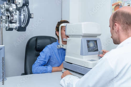 Handsome male ophthalmologist is examining the vision of an attractive young woman in a modern clinic, doctors and patients in ophthalmology clinics.