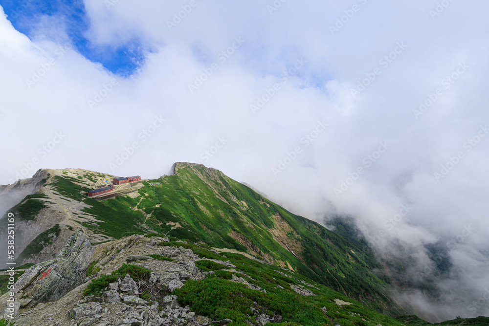 雲が立ち込める唐松岳山頂から望む唐松岳頂上山荘