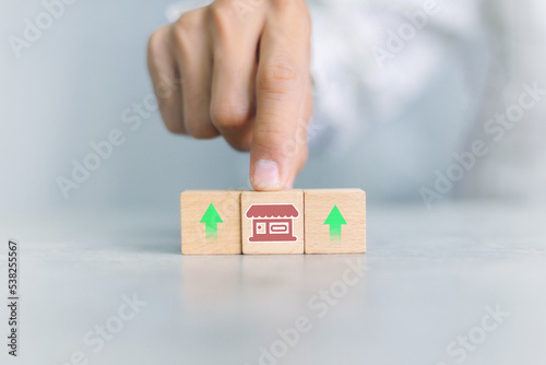 Franchise business,Businessman hand choose wooden blog with franchise marketing icons Store.Franchise business concept.