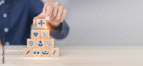 Hand arranging wood block stacking with icon healthcare medical, Health insurance - concept. photo