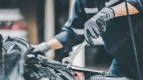 Mechanic works on the engine of the car in the garage. Repair se