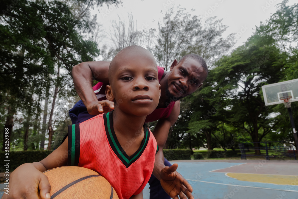 Obraz premium Parent and son playing basketball