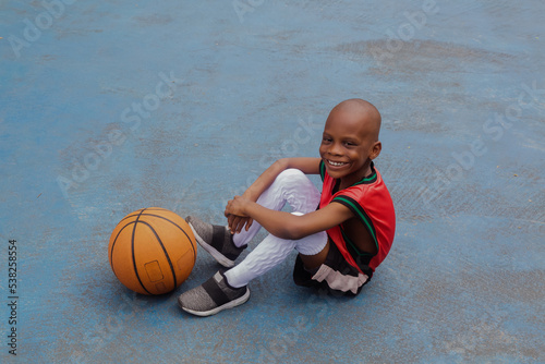 Child sitting at the basketball court