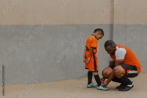Father adjusting laces for son 
