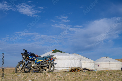 Motorcycle near traditional Mongolian yurts in the Mongolian steppe