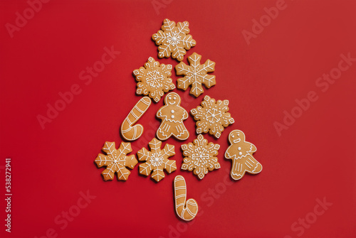 Christmas tree made of gingerbread cookies on a red festive background. Winter traditional treat