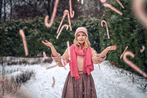 New Year's photos of a beautiful girl in the forest with a decorated Christmas tree, filled with comfort and magic. Magic. Girl and lollipops flying around the frame 