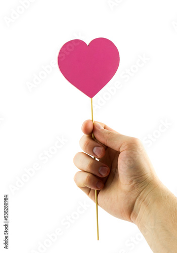 Hand holding pink wooden heart on stick isolated on white background