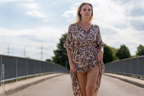 Attractive confident provocative woman on a bridge photo