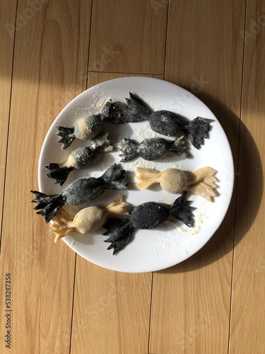 Squid ink gyozas in the shape of caramelle pasta 