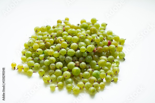 Hill of green gooseberries on a white background.