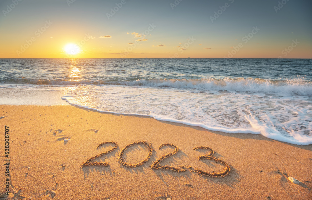 Fototapeta premium 2023 year on the sea shore during sunset.