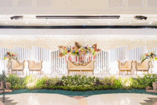 Indonesian wedding stage aisle decorated with colorful natural flowers photo