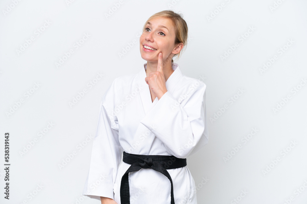 Young caucasian woman doing karate isolated on white background thinking an idea while looking up Young caucasian woman doing karate isolated on white background thinking an idea while looking up