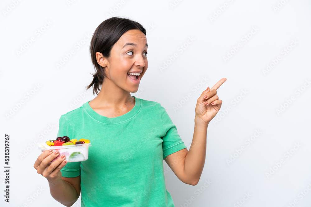 Young hispanic woman holding a bowl of fruit isolated on white background intending to realizes the solution while lifting a finger up Young hispanic woman holding a bowl of fruit isolated on white background intending to realizes the solution while lifting a finger up