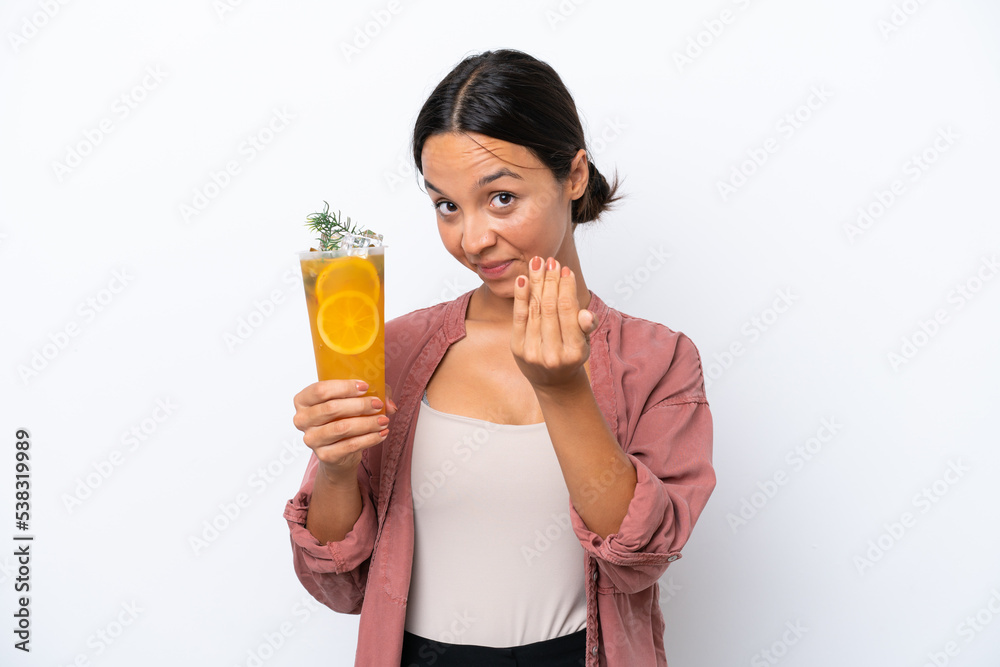 Young hispanic woman holding a cocktail isolated on white background inviting to come with hand. Happy that you came Young hispanic woman holding a cocktail isolated on white background inviting to come with hand. Happy that you came