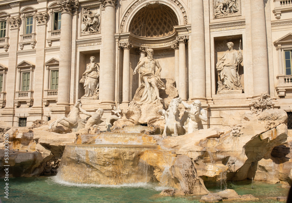 Trevi Fountain in Rome, Italy. Ancient fountain. Roman statues at piazza in old medieval city among traditional italian houses and street lamps. Famous landmark.
