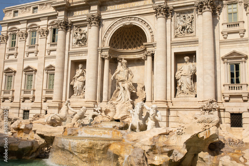 Trevi Fountain in Rome, Italy. Ancient fountain. Roman statues at piazza in old medieval city among traditional italian houses and street lamps. Famous landmark.