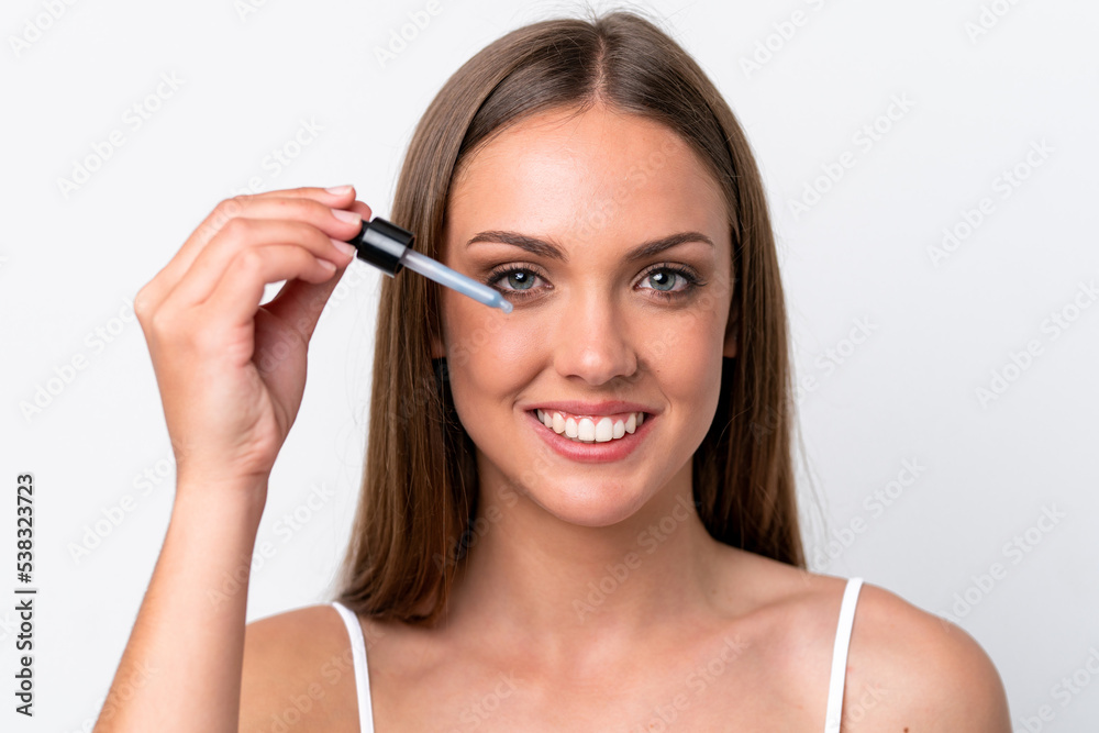 Young caucasian woman isolated on white background holding a serum while smiling. Close up portrait Young caucasian woman isolated on white background holding a serum while smiling. Close up portrait