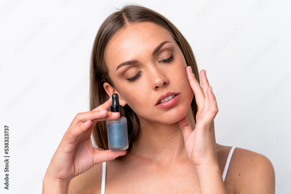 Young caucasian woman isolated on white background holding a serum. Close up portrait Young caucasian woman isolated on white background holding a serum. Close up portrait